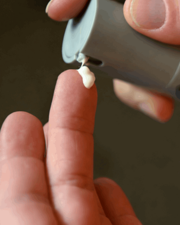 Crème uit de dispenser op een vinger